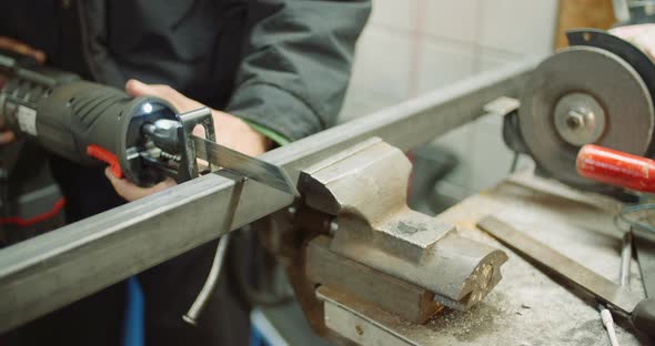 Industry Worker Metal Part with Electric Hacksaw alt