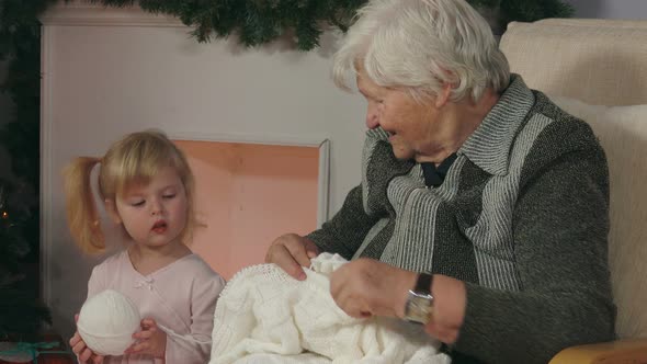 Grandmother Shows To Her Granddaughter How To Knit alt