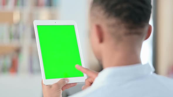 African Man Using Tablet with Green Chroma Key Screen Rear View alt