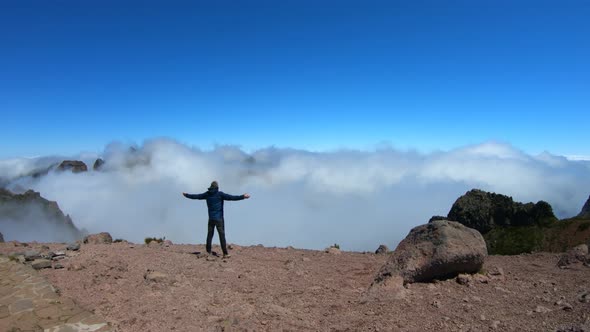 Man with arms wide open on Pico do Arieiro to Pico Ruivo hike, Madeira alt