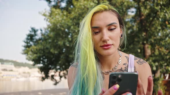 Close Outside Portrait of a Young Girl with a Smartphone in Her Hands alt
