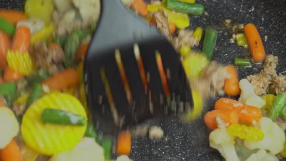 Close up view of steaming frying pan and mixed vegetables with frying minced. alt