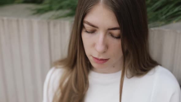 Young Female in Garden Using Laptop Communicates on Internet with Customer
