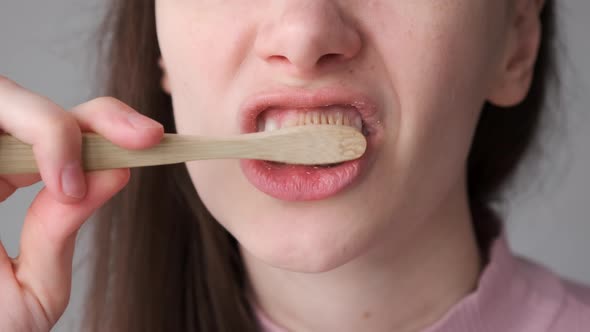 Woman with Organic Bamboo Toothbrush and Toothpaste Brushing Her Teeth