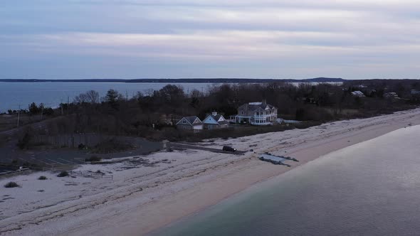 an aerial view over a narrow beach in Orient Point, New York during a cloudy sunset. The camera doll alt