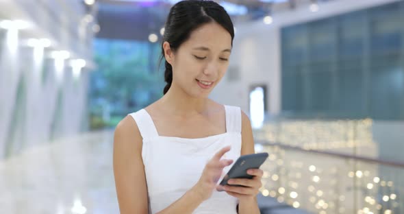 Woman use of cellphone in shopping center alt