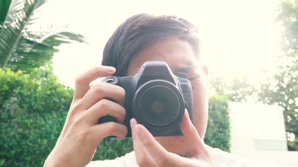 Young Male Photographer Taking Photos During Sunset with Backlighting Lens Flare From Behind alt