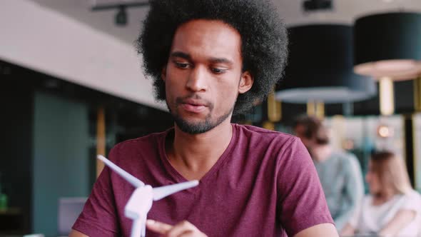 African man with model of wind turbine alt