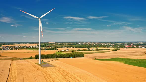 Harvest on field and wind turbine in summer, aerial view alt