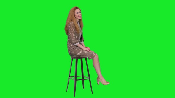 Elegant Woman Sitting on Chair and Telling a Story to the Audience Against Green Screen