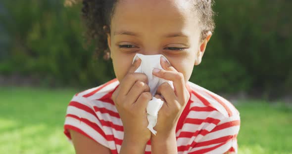 African american girl blowing her nose outside alt