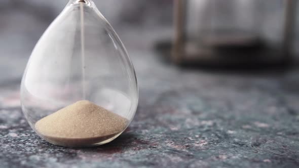 Hourglass on Table Sand Flowing Through the Bulb of Sandglass alt