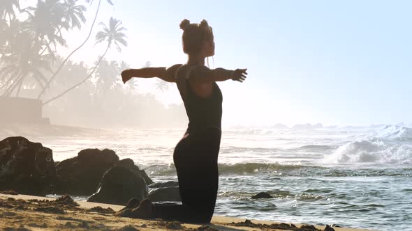 Sporty Girl in Black Tracksuit Practices Yoga Pose Pigeon alt