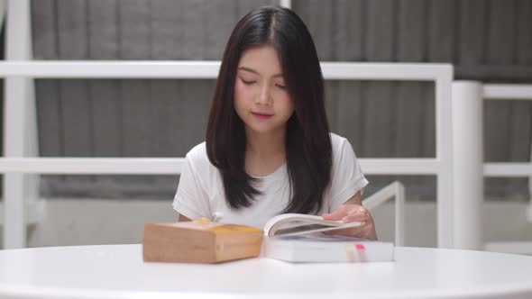 Young undergraduate girl do homework, read textbook, study hard for knowledge and education alt