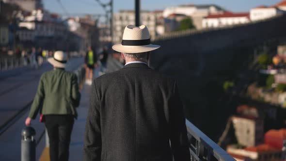 White Hat Tourist Walks on Bridge De Dom Luis I
