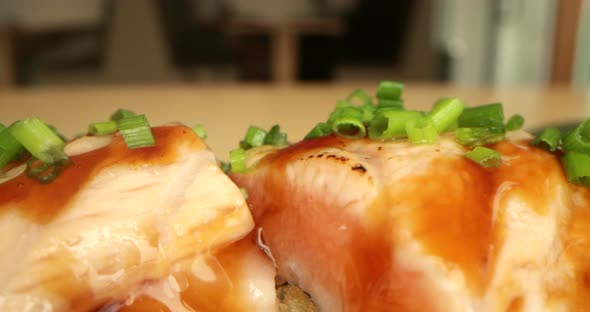Salmon Sushi Rolls Garnished With Fresh Onion Chives - macro, slow panning shot alt