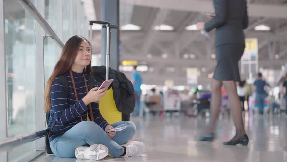 Young female traveler feel boring to waiting someone at airport