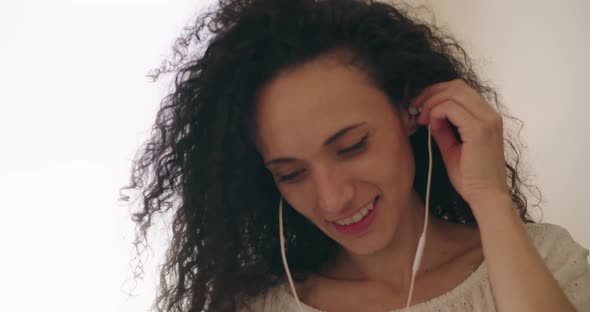 Woman putting on an earphone alt