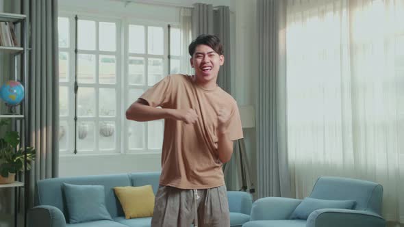 Asian Man Dancing While Shooting Video Content For Social Networks At Home alt