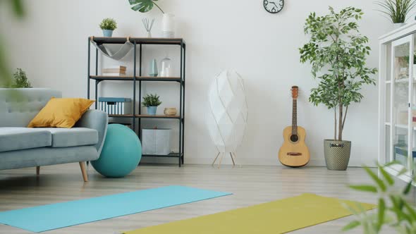 Modern Studio Apartment with Furniture and Sports Equipment Yoga Mats Fitball and Dumbbells alt