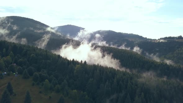 Overhead Aerial Drone Shot Pulling Back Revealing Moving Valley Fog on a Romanian Mountainside. alt