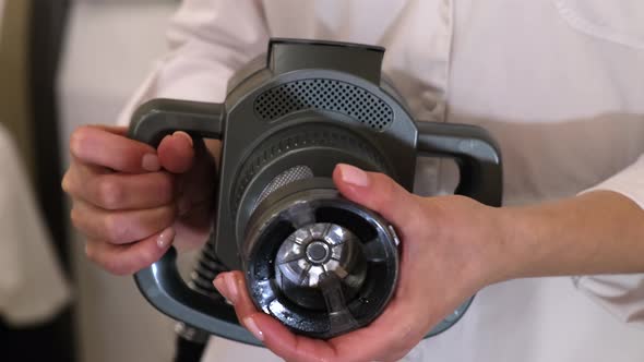 Beautician is changing the head in the massage machine. Close-up. Slow motion. alt