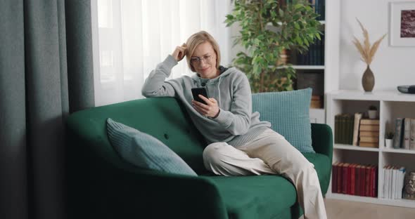 Woman on Sofa Using Smartphone
