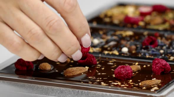 Close-up Decorating of Handmade Chocolate Bars with Spices, Dry Berries and Nuts