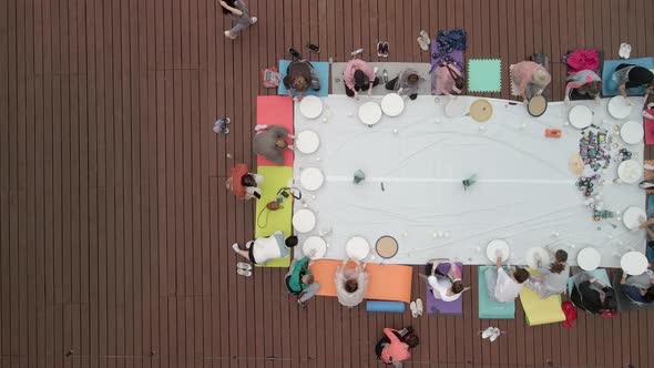 Aerial View of a Large Group of People Learning the Art of Drawing with Paints on a Round Board