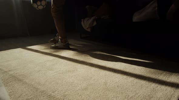 Man Professional Football Player Training and Controlling a Soccer Ball in the Living Room at Home alt