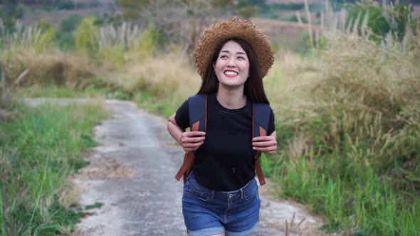slow-motion of woman with backpack walking on footpath in nature alt