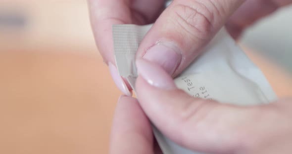 Woman's Hand Tearing Off The Packaging Of Antigen Rapid Test Cassette Kit For COVID-19. - close up s alt