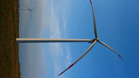 Wind turbine in an offshore wind farm in the green field against low sun on sunrise the close-up.