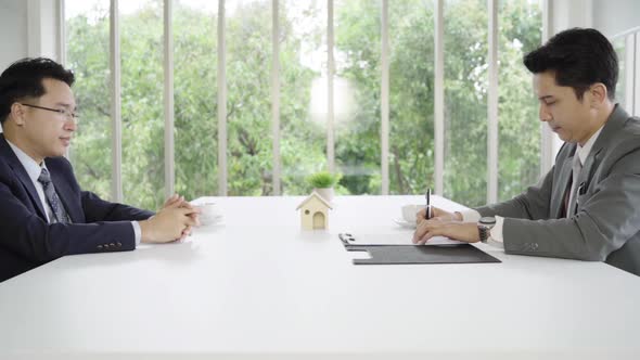 Businessman signing a home contract and check agreement alt