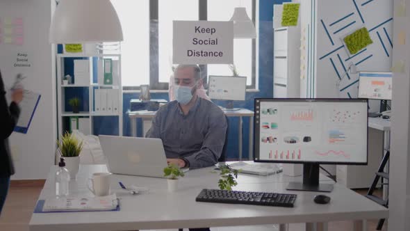 Adult Woman with Medical Face Mask Measure Team Temperature Using Infrared Thermometer alt