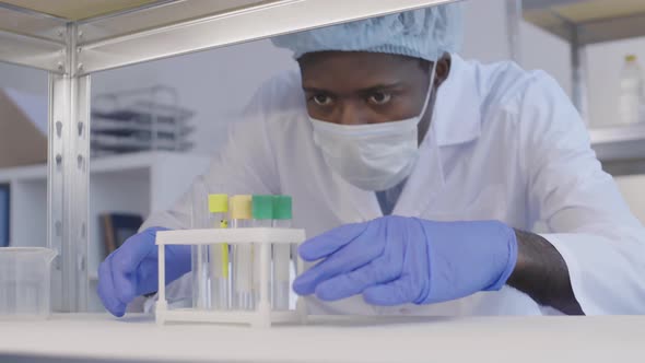 African Scientist Wearing Protective Uniform in Lab alt