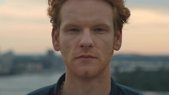 Good Looking Redhead Man Standing Outdoors with Serious Facial Expression Looking at Camera alt