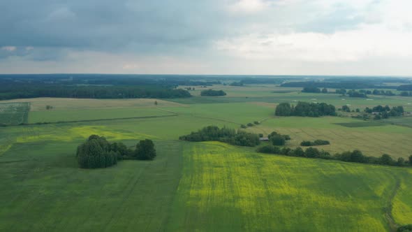 Spectacular landscape flight above green expansive flat plains and farmland in rural countryside on alt