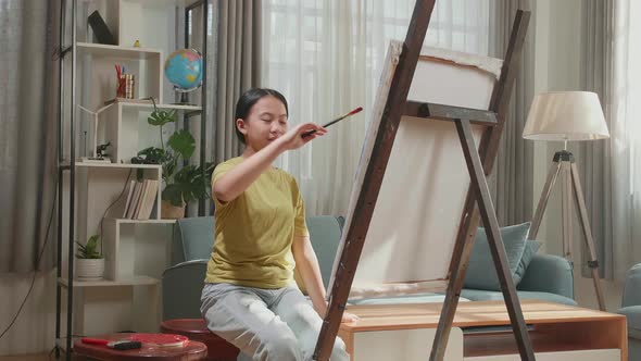 Asian Artist Girl Holding Paintbrush Wipe The Sweat Before Crossing His Arms And Smiling alt