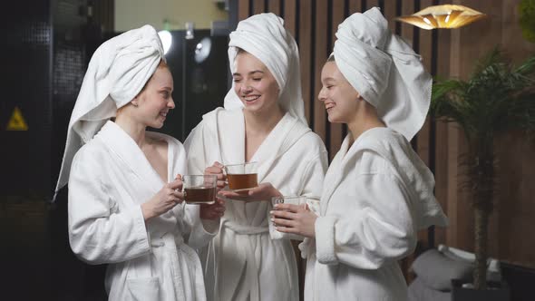 Three Girlfriends Drinking Herbal Tea After Spa Treatment Having Rest Enjoying Beauty Procedures