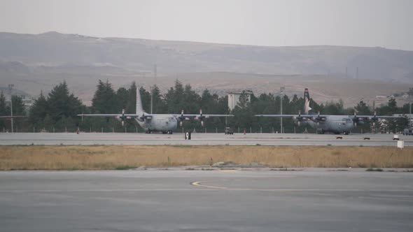 Large Airplanes Stand on Local Airport Airfield Against Hill alt