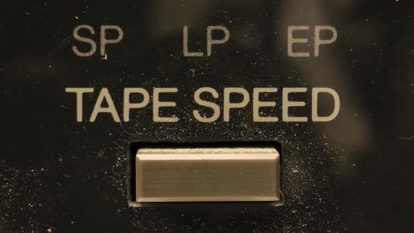 Extreme close up of buttons on an old antique or vintage VCR.  A finger pushing a button switching b alt