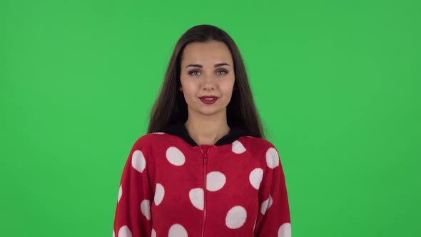 Portrait of Beautiful Girl in Red Fleece Pajamas Is Standing, Spreads Out in a Smile. Green Screen alt