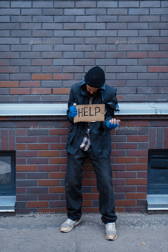 Beggar man and help sign on city street