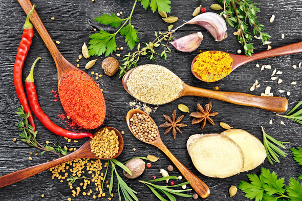 Spices in spoons on black board top - Stock Photo - Images