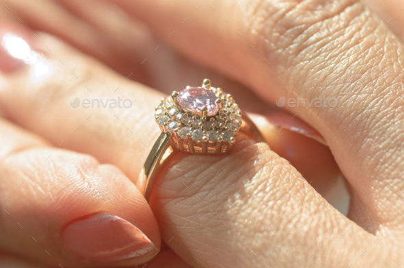 Close-up view of a diamond ring and woman hand