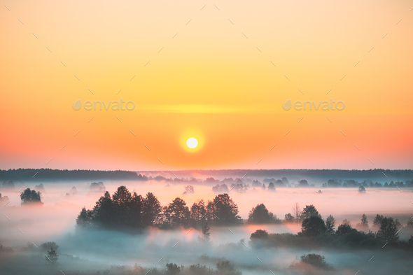 Amazing Sunrise Sunset Over Misty Landscape. Scenic View Of Foggy Morning Sky With Rising Sun Above - Stock Photo - Images