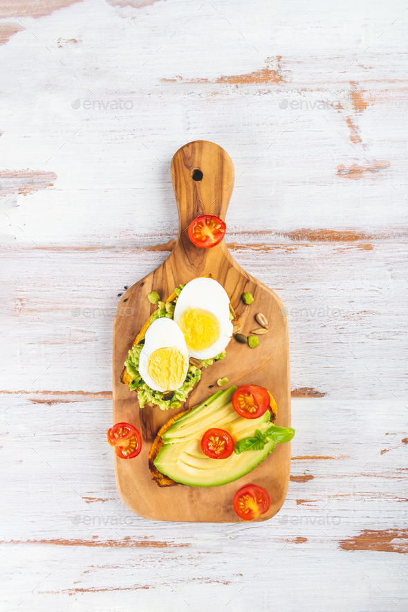 Sweet potato toasts with avocado, eggs, tomatoes and sesame seeds - Stock Photo - Images