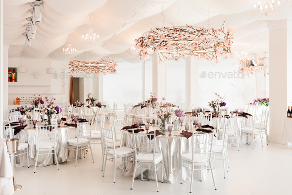 Amazing floral decorated white wedding hall with tables