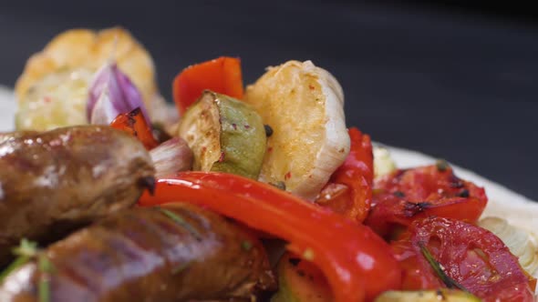 Slow Motion Shooting of Falling Peppers and Seasoning for a Serving of Grilled Pork Sausages